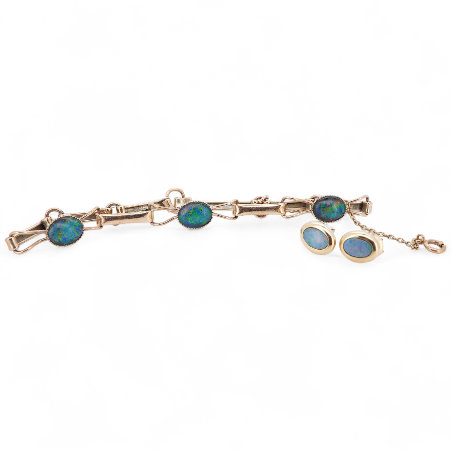 An opal triplet bracelet and pair of earrings, comprising: a gold bracelet set with opal triplets, length 18cm; and a pair of studs set with opal doublets, mounted in gold, length 0.8cm each, post fittings, stamped 585,